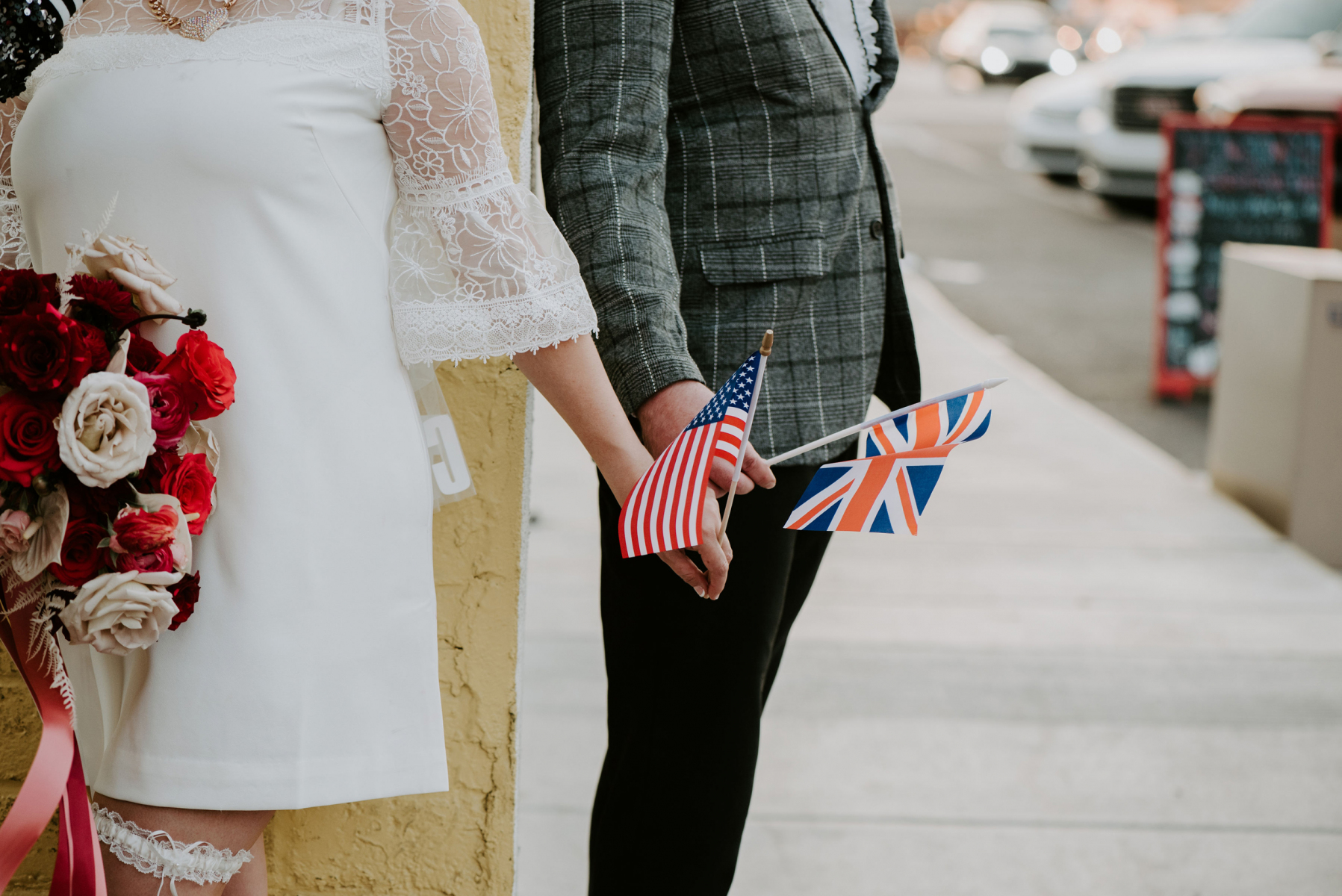 Couple standing at different corners with their country flag in hand.