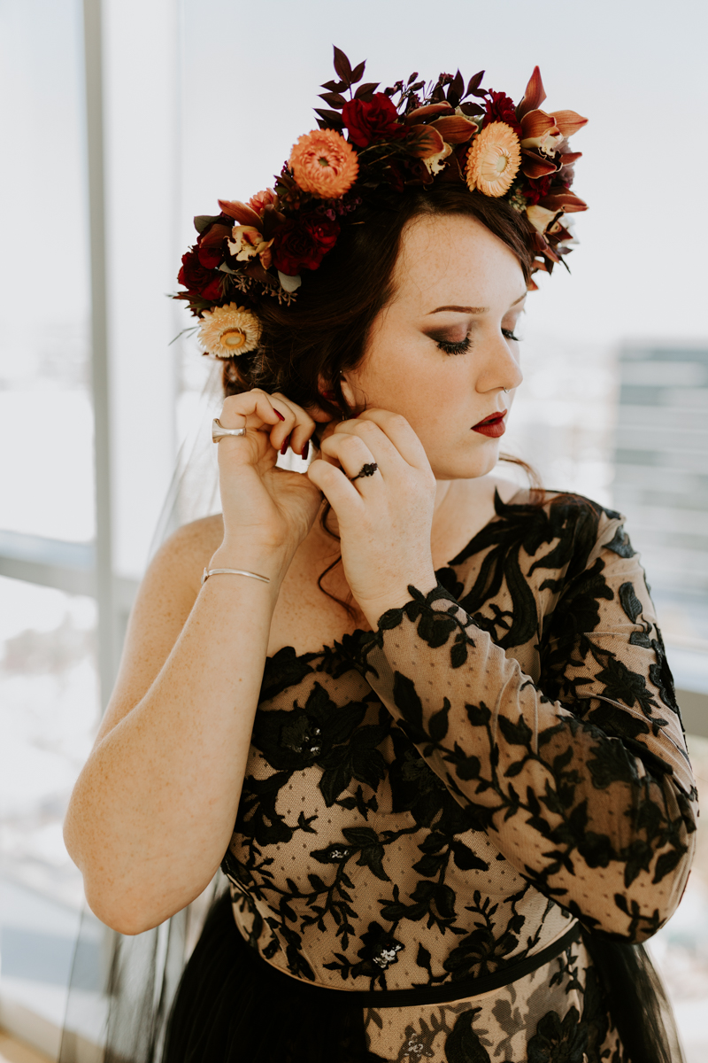 gothic bride putting on earrings