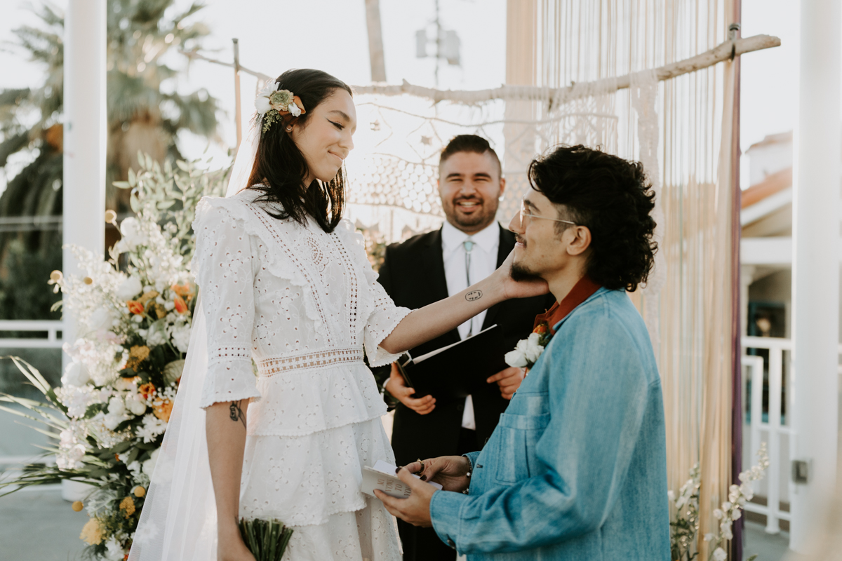 tall bride and groom wearing vintage blue suit saying vows